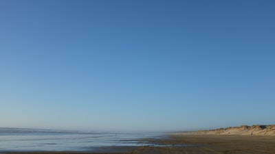 蓝天下的水体和灰色海岸
